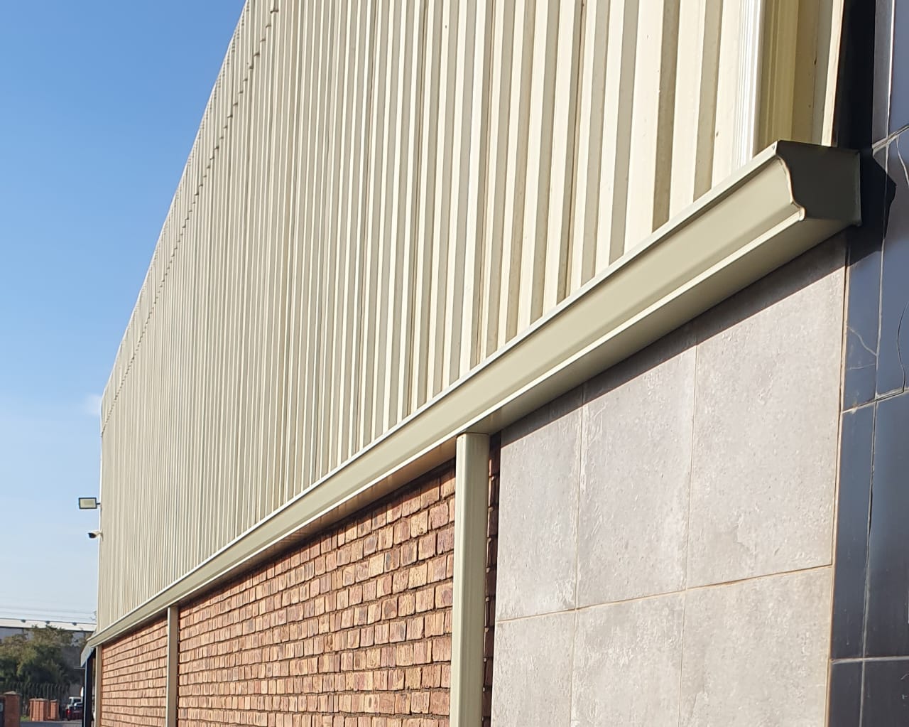 Mitred box gutter corner on a cream clad industrial building